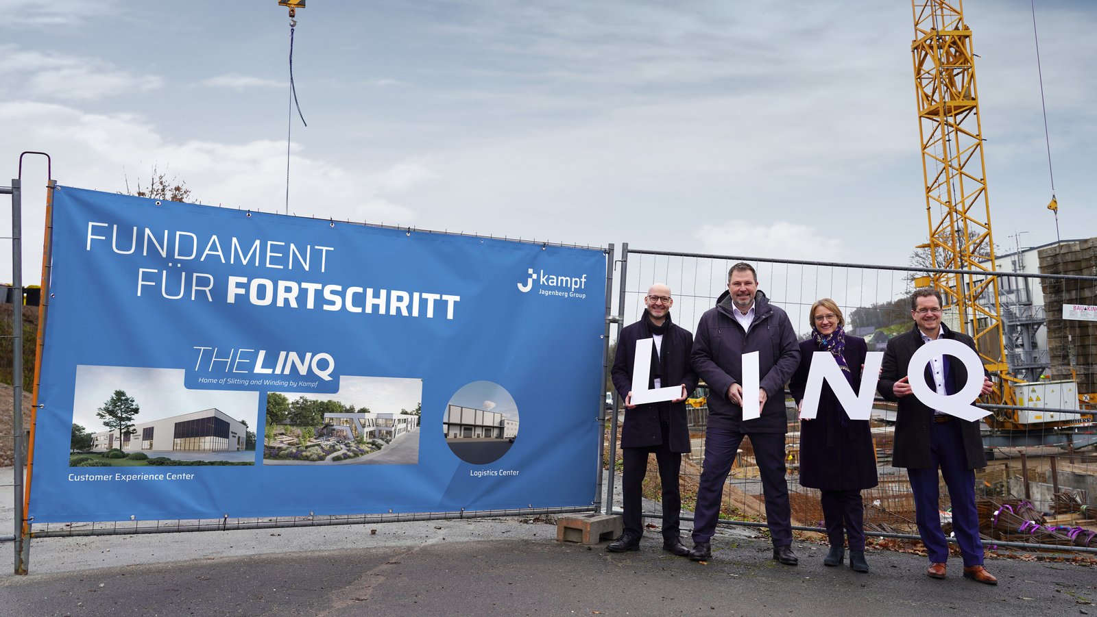 Das Bild zeigt 4 Mitarbeiter von Kampf vor der Baustelle