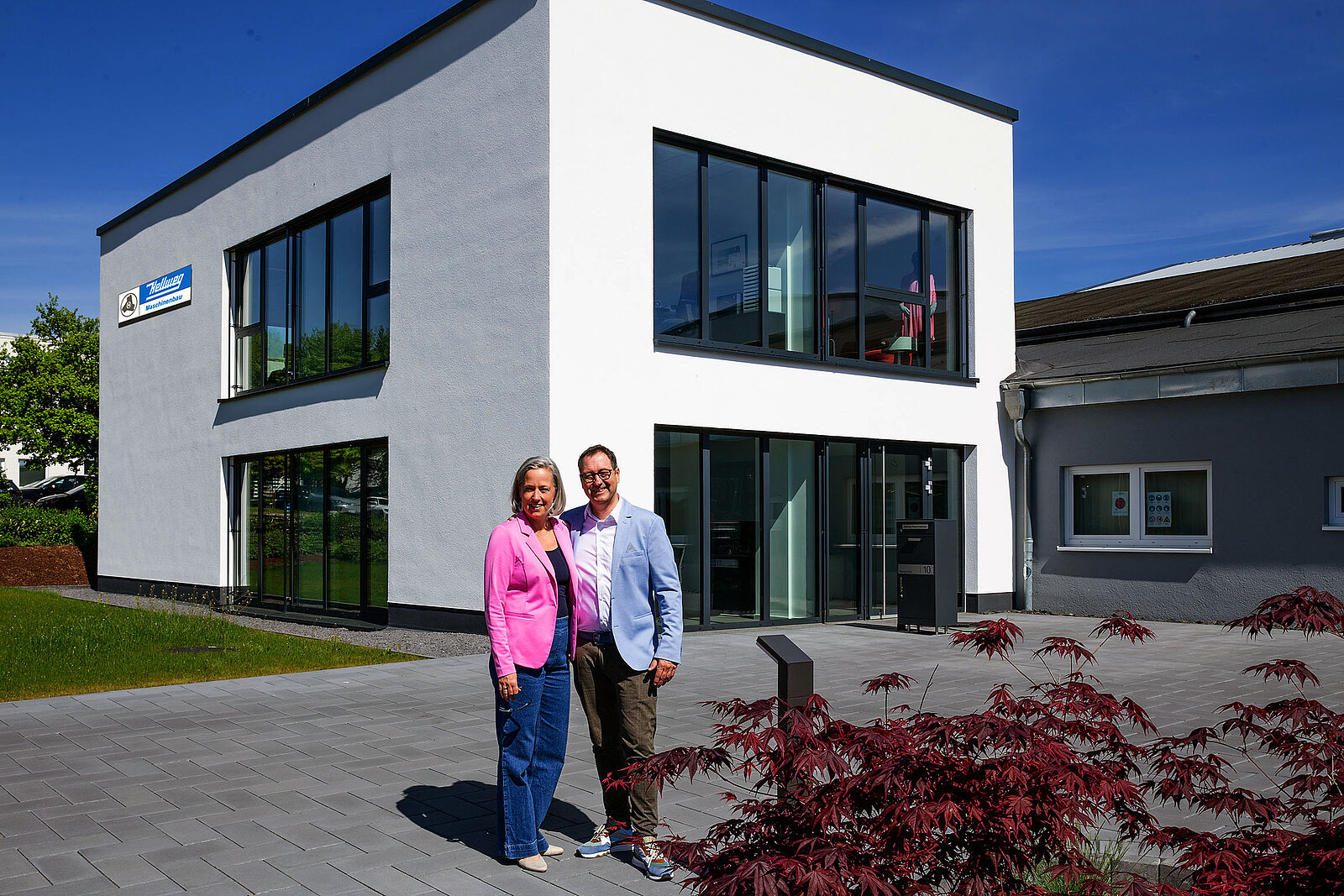 Auf dem Bild sieht man die beiden Geschäftsführer vor dem neuem Gebäude